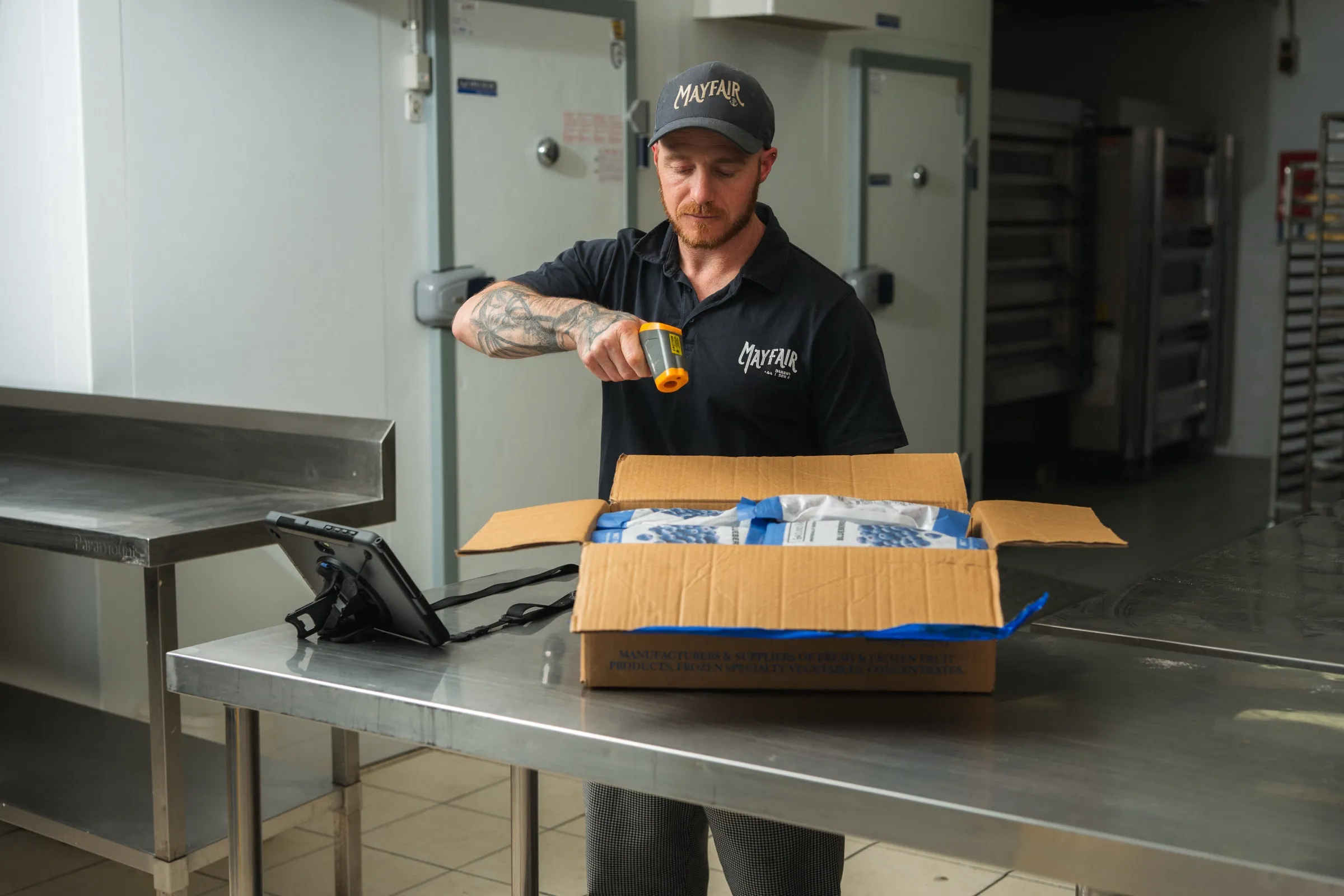 A Mayfair Bakery team member checking the temperature of a blueberry delivery